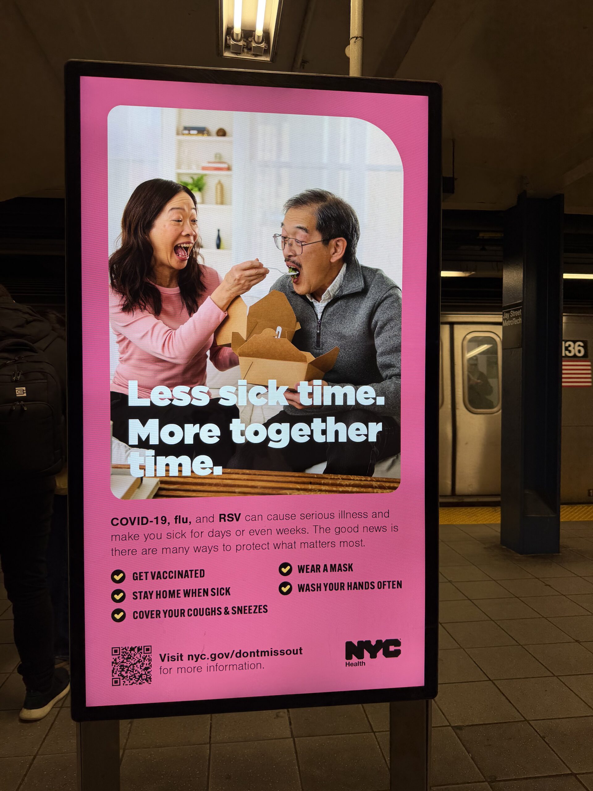 NYC地下鉄のピンクポスター:Less sick time. More together time. ご夫婦が食事を楽しむシーン